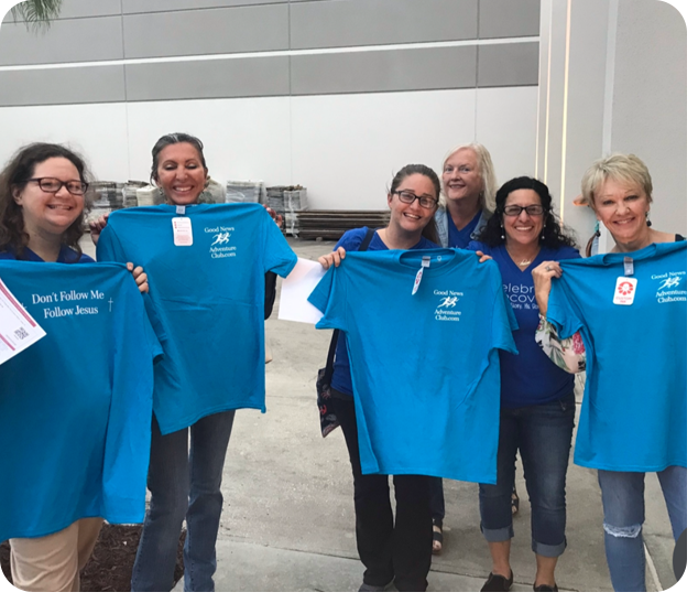 A group of people holding up blue shirts.