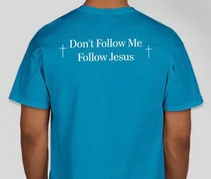 A person wearing a blue shirt with the words " don 't follow me, follow jesus ".