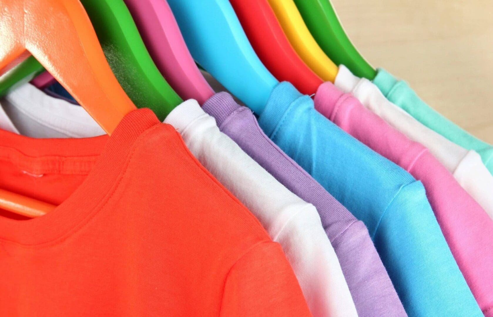 A bunch of different colored shirts hanging up