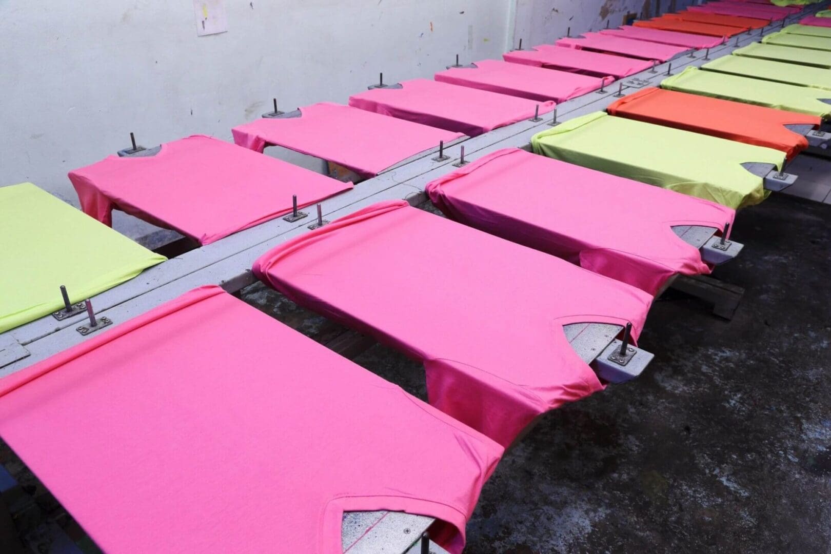 A row of pink beds in a room.